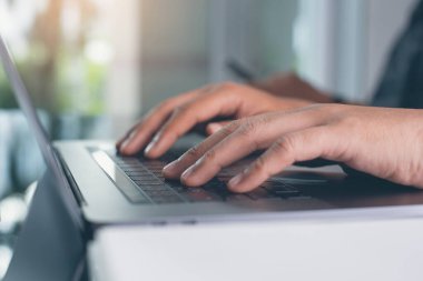 Close up of two business men typing on keyboard, working on laptop computer at office. Startup business, online working concept