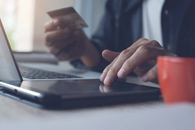 Online payment, casual man holdings credit card using digital tablet for online shopping with copy soace. Financial technology, Fintech concept, toned