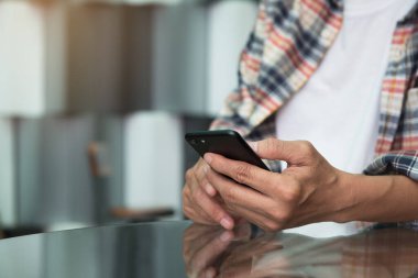 Casual business man or freelancer using mobile smartphone in coffee shop or resturant while waiting for someone