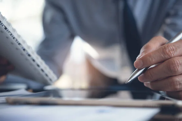 Business analysis, investment and finance concept. Business man, accountant holding pen, analyzing business report, marketing data, financial graph on digital tablet computer, spreadsheet on office desk, close up