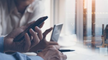 Start up businessmen  brainstorming new project in office, using smartphone and laptop computer on table, flare light, teamwork on start up  business concept