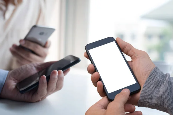 Mock up image of young men or hipsters using mobile smartphone together,  social media communication, checking internet application on smartphone, digital software development, close up