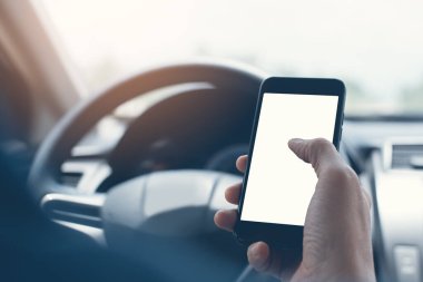 Man using blank white screen mobile smartphone inside a car in sunny day, copy space for your advertisement, vintage tone
