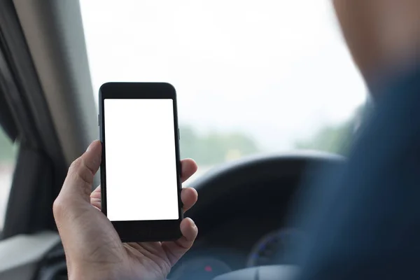 Man using and looking at blank screen mobile smartphone inside a car in sunny day, copy space for your advertisement