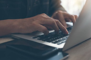 Sıradan bir iş adamı, dizüstü bilgisayar klavyesinde daktilo yazan bir serbest yazar. Bir fincan kahve, akıllı telefon, masadaki dijital tablet, kahve dükkanından internet üzerinden çalışan bir adam, kapat..