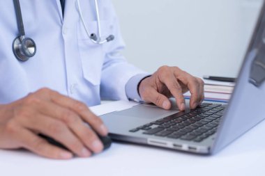Dizüstü bilgisayar, elektronik sağlık kayıtları EHR 'ler, elektronik tıbbi kayıt sistemleri EMR' ler, teletıp konsepti üzerinde çalışan erkek doktorları kapatın..