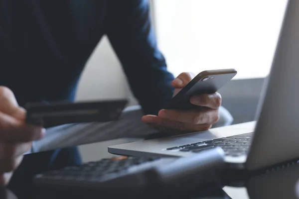 Çevrimiçi ödeme, dijital bankacılık. Akıllı cep telefonunu elinde tutan bir adam, online alışveriş için kredi kartı kullanıyor. Bilgisayarlı ve tabletli. Siber pazartesi konsepti