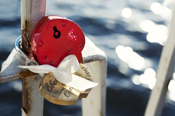 Red heart shaped love locks on the fence of the bridge — Stock Photo, Image