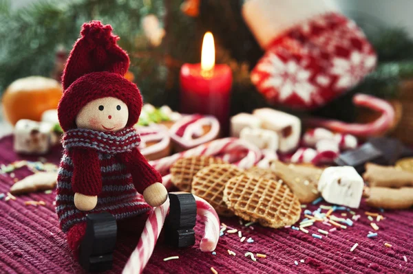 Poupée souriante en bois avec des bonbons sur fond de Noël avec boîte — Photo