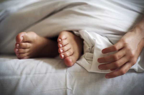 Spanie dziecka stóp i dłoni na pościel — Zdjęcie stockowe