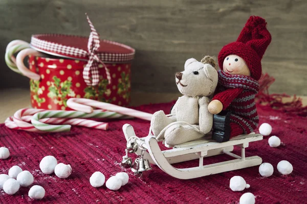 Weihnachtsdeko - Miniaturspielzeug auf Schlitten. Geschenkbox mit Süßigkeiten — Stockfoto