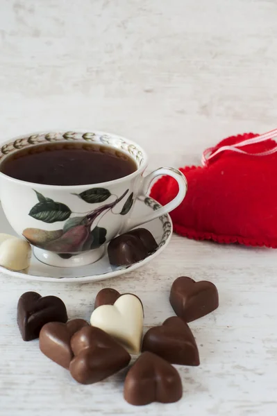 हृदयाच्या आकाराच्या चॉकलेट्ससह चहा कप — स्टॉक फोटो, इमेज