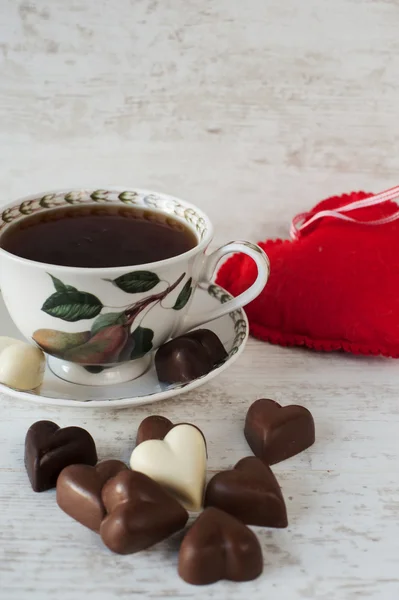 Xícara de chá com chocolates em forma de coração — Fotografia de Stock