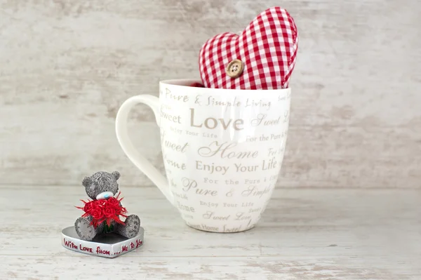 Valentijn miniatuur teddybeer en rood hart op houten pagina — Stockfoto