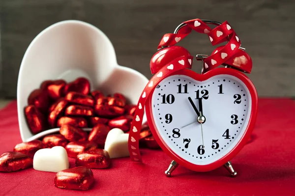 Valentijn hartvormige rode liefde klok met chocolade — Stockfoto