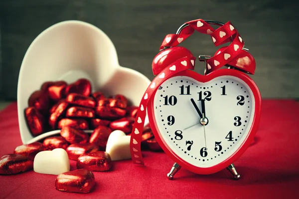 Valentýn ve tvaru srdce červené lásky hodiny s čokoládou — Stock fotografie