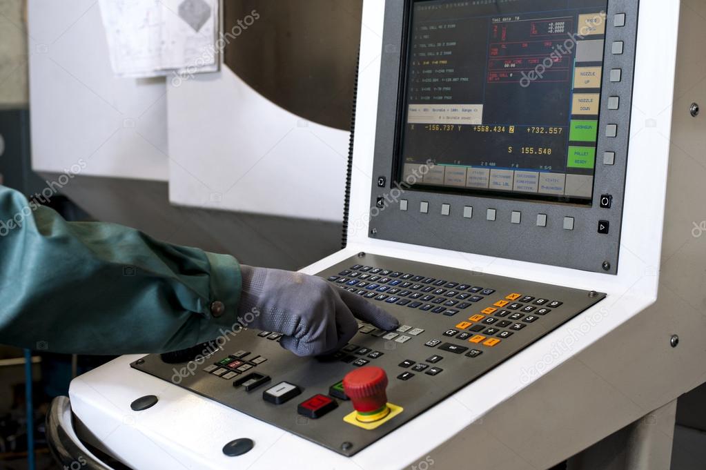 Hand on the control panel of a cnc programmable machine