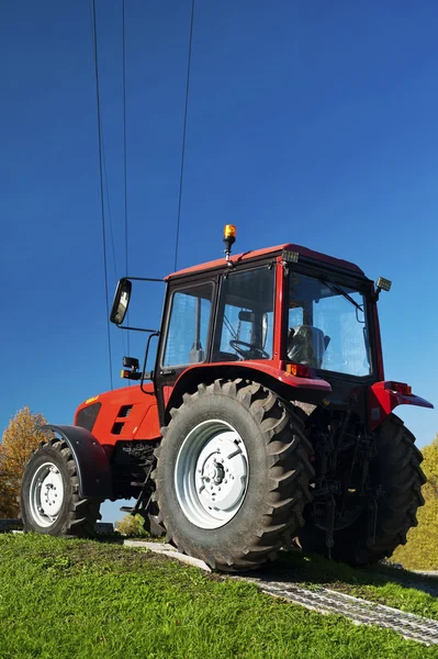 Moderne rode trekker buitenshuis — Stockfoto