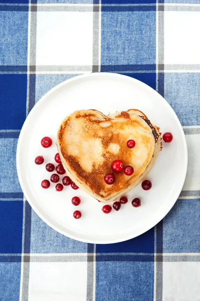 Liebe Herz Pfannkuchen mit Preiselbeeren auf Porzellanteller. Nahaufnahme — Stockfoto