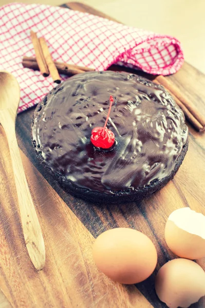 Gâteau au chocolat maison rond sur fond en bois avec fi rétro — Photo