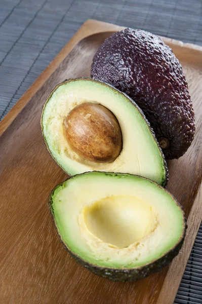 Avocado maturo su piatto di legno. Primo piano . — Foto Stock