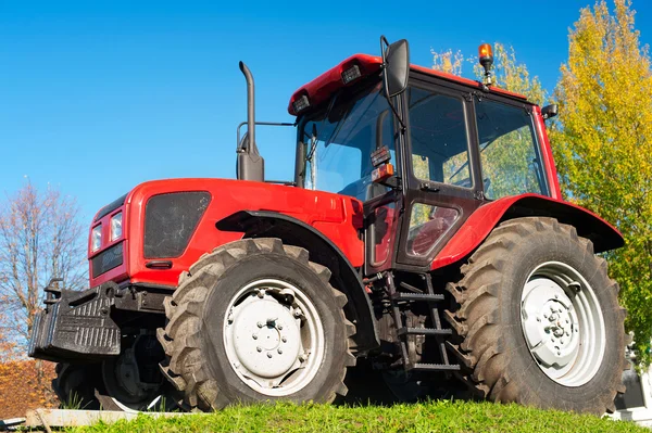 Moderner roter Traktor auf blauem Himmel — Stockfoto