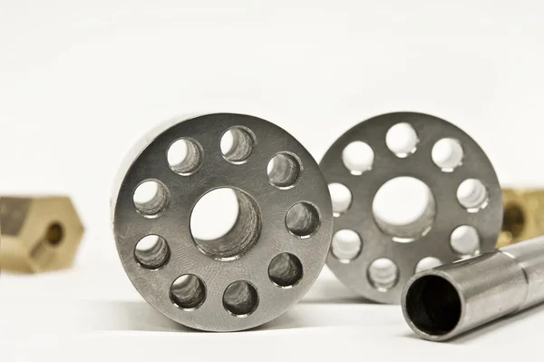 Metal flanges cylinders and brass nuts. — Stock Photo, Image