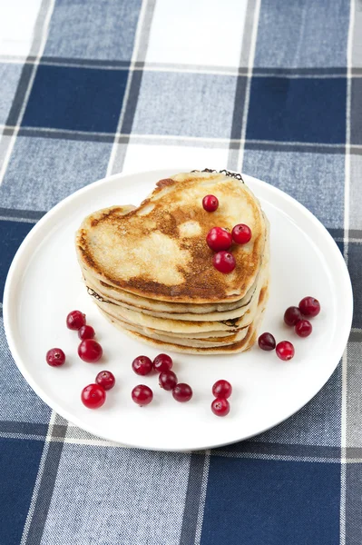 Heart shaped pancakes with cranberries on porcelain plate. Close — Stock Photo, Image