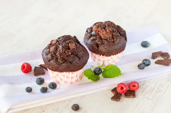 Dos deliciosas magdalenas de chocolate caseras en pape de cocina de colores —  Fotos de Stock