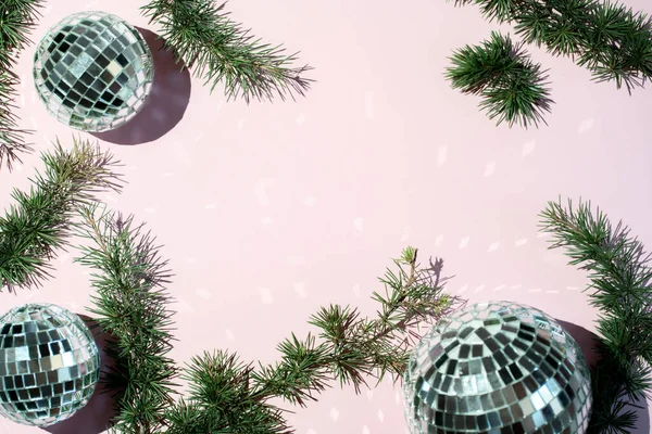Fundo de decoração de Natal colorido em um fundo rosa. Bolas brilhantes e ramos de uma árvore de Ano Novo em um contexto rosa. — Fotografia de Stock