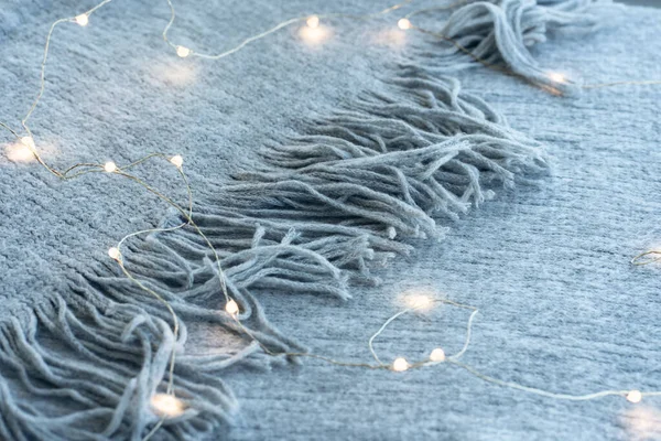 Led guirlanda quente no fundo cobertor de lã, conceito moderno. Close-up de um cobertor de malha. — Fotografia de Stock