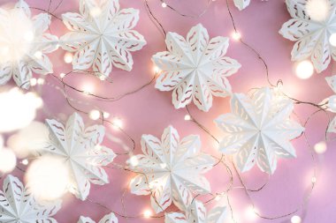 Kağıttan yapılmış çevre dostu Noel oyuncakları, pembe bir arka planda Noel çelengi. Çevre dostu, parlak Noel geçmişi