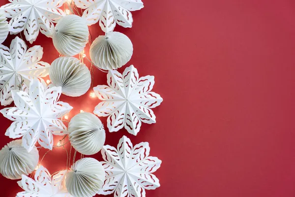 Modieuze eco-vriendelijke kerstboom speelgoed gemaakt van papier, kerstslinger op een rode achtergrond. Milieuvriendelijke glanzende kerst achtergrond — Stockfoto