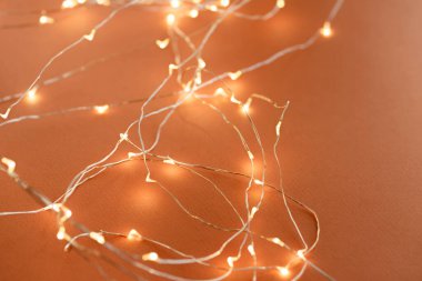 Odaklanmış turuncu arka plan. Bir sürü ışıklandırması olan ışıldayan bir çelengin Noel arkaplanı. Yeni yıl kutlaması konsepti