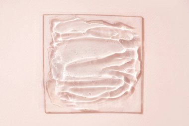 Kozmetik ürün damlaları veya bej arka planda köpüklü sıvı şeffaf jel.