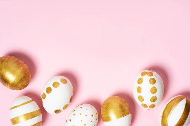 Pembe pastel arka planda el yapımı paskalya yumurtaları. Birçok Paskalya yumurtası düz arkaplanda yatar.