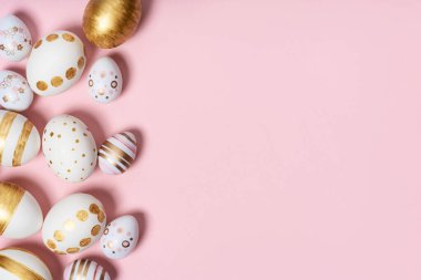 Pembe pastel arka planda el yapımı paskalya yumurtaları. Birçok Paskalya yumurtası düz arkaplanda yatar.