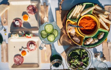 Kahvaltı, tahtadan çatal bıçakla Biyoçözünür çevre dostu bambu tabaklarda servis edilir. Ekolojik geri dönüşümlü masa seti içinde sıralanmış kızarmış yumurta ve jambon porsiyonları. Paskalya pikniği için organik gıda