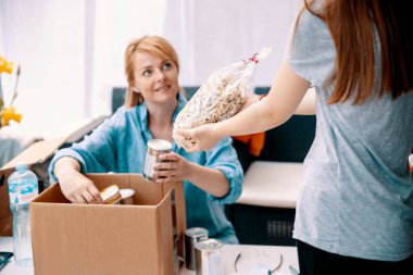Kızlı Kadın bağış kutusunu kilit altında tutuyor. Paket Bağışlarla Hazırlanıyor