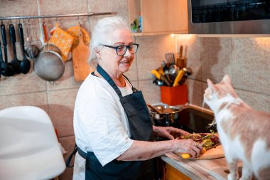 Son sınıf öğrencisi kadın mutfakta yemek pişiriyor.