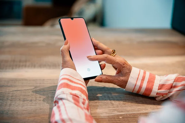 Senior female hands using mobile phone, connecting online to chat. Close up Old hands typing on the smartphone display.