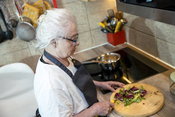 Son sınıf öğrencisi kadın mutfakta yemek pişiriyor.
