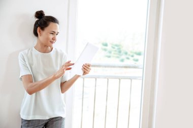 Tablet kullanan genç bir kadın.  
