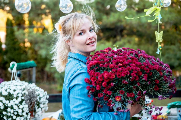 Yeni iş yapan kadın bahçesinde çiçeklerle meyve yetiştiriyor.