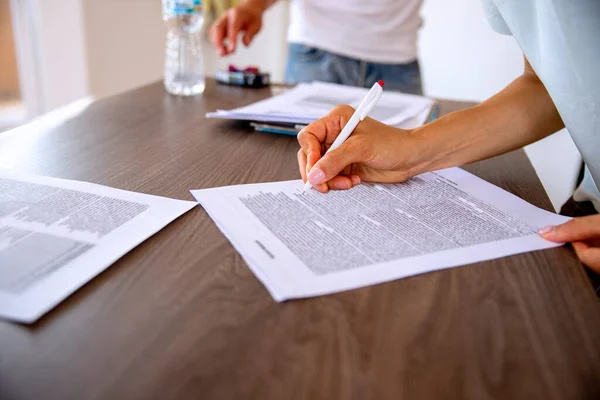woman signing contract at table in the office