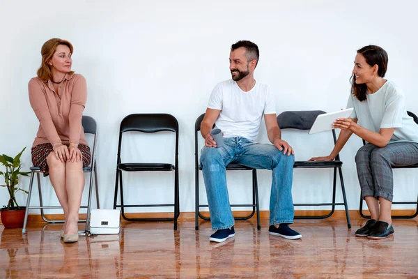 People sitting on chairs in a row. Group of Multiethnic people in waiting room