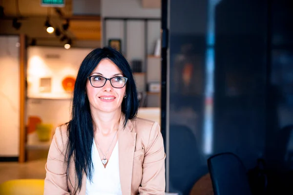 portrait of a beautiful young woman in a suit and glasses in the office