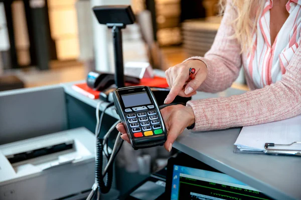 Kadın kredi kartı ve NFC ile ödeme yapıyor.