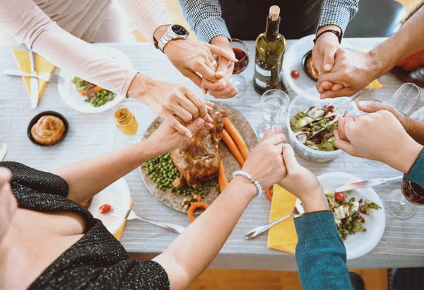 陽気な多民族の友人がお祝いの夕食を食べ 食べ物や笑いと一緒に休日を楽しんでいます 感謝祭の日にキッチンテーブルを囲んで家族の集まり — ストック写真