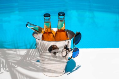 Bira şişeli buz kovası ve havuz kenarında fıstık. Tropik tatil rahatlaması. Boşluğu kopyala